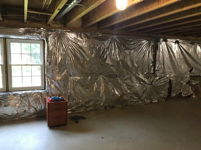 Unfinished basement with exposed insulation and concrete floors